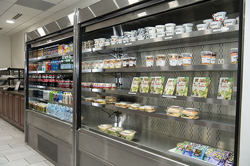 Grab-and-go food and beverage items on metal shelves.