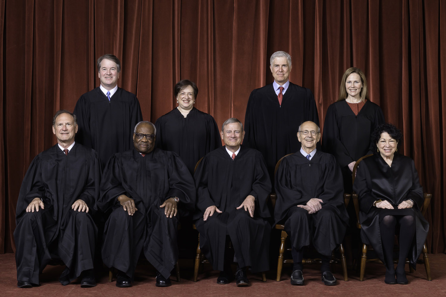 Justices of the United States Supreme Court stand for the Court's official photograph. At rear from left to right: Justices Brett Kavanaugh, Elena Kagan, Neil Gorsuch, and Amy Coney Barrett. Sitting at front from left to right: Justices Samuel Alito, Clearance Thomas, Chief Justice John Roberts, Stephen Breyer, and Sonia Sotomayor.