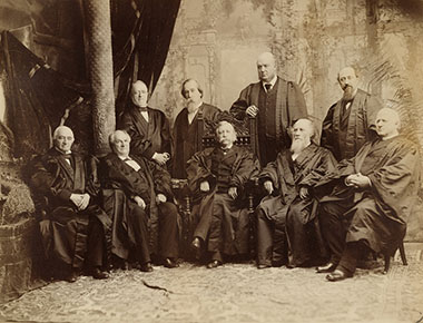 Less than a month after Justice David J. Brewer took his seat on the Court, the Justices posed for this group photograph in which Justice Brewer (standing, far right) stands behind his uncle, Justice Stephen J. Field (seated, second from right).