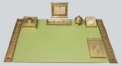 Tiffany desk set presented to Justice Harlan Fiske Stone. An inscription on the underside of the notepad cover reads, “To Mr. Justice Stone on his fifteenth anniversary as a Justice of the Supreme Court of the United States with the affectionate regard of his Law Clerks.” A medallion incorporating Stone’s initials, “HFS,” is found on components of the desk set.
