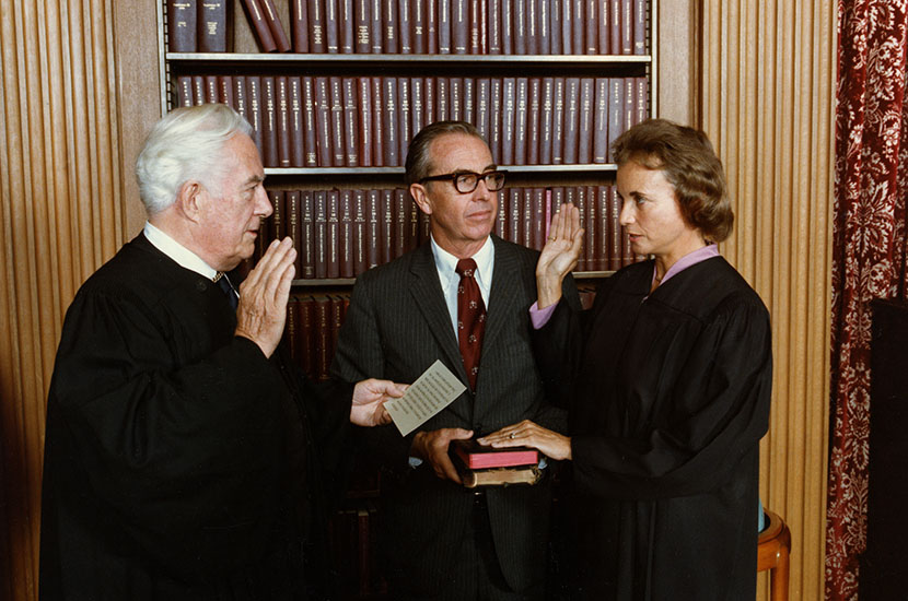 Chief Justice Warren E. Burger administers the Judicial Oath to Judge Sandra Day O'Connor while her husband, John J. O'Connor, holds the family Bibles.