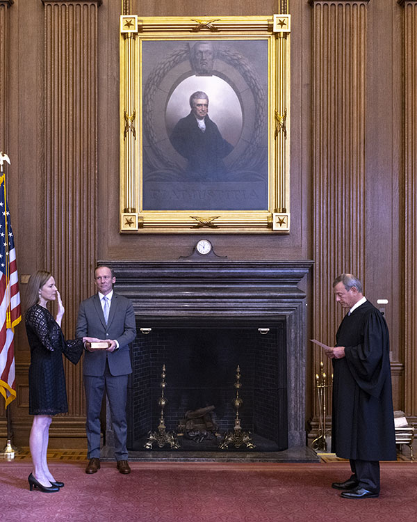 Chief Justice John G. Roberts, Jr., administers the Judicial Oath to Judge Amy Coney Barrett in the East Conference Room, Supreme Court Building. Judge Barrett’s husband, Jesse M. Barrett, holds the Bible.