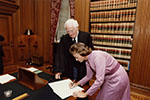 Justice Sandra Day O'Connor signs her oaths of office in the Justices' Conference Room alongside Chief Justice Warren E. Burger, 1981
