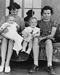Ada Mae Day holding her son, Alan Day, seated beside her daughters, Ann and Sandra Day, age 11