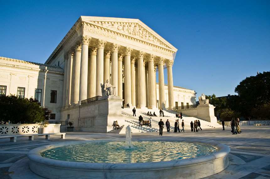 The Supreme Court Building facade and front plaza with a fountain in the foreground. Several visitors
stand on the plaza and on the building�s front steps.